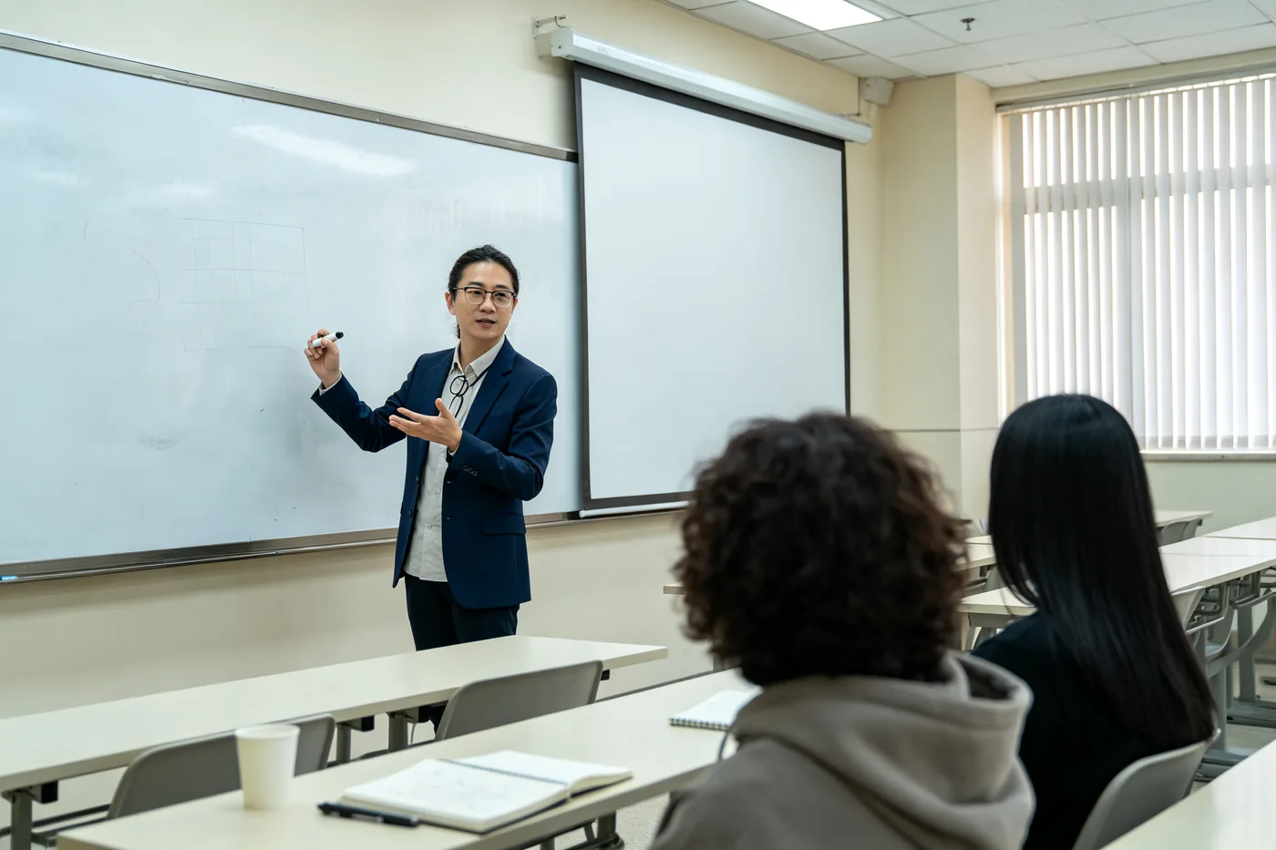 Chinese teacher leading a language class at a whiteboard