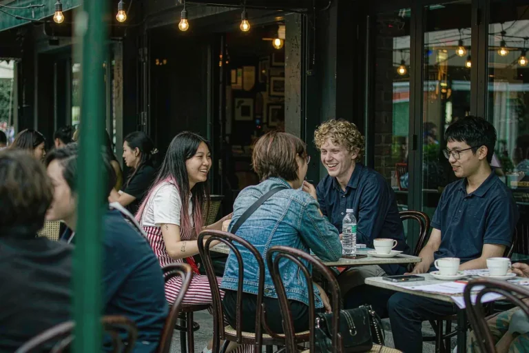 International and Chinese students chatting and laughing together at an outdoor cafe in China