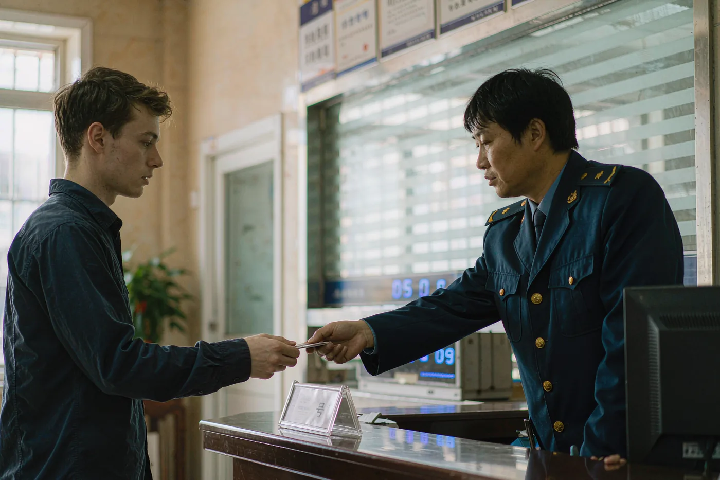 Foreign visitor handing passport to a staff member at a Chinese community service office