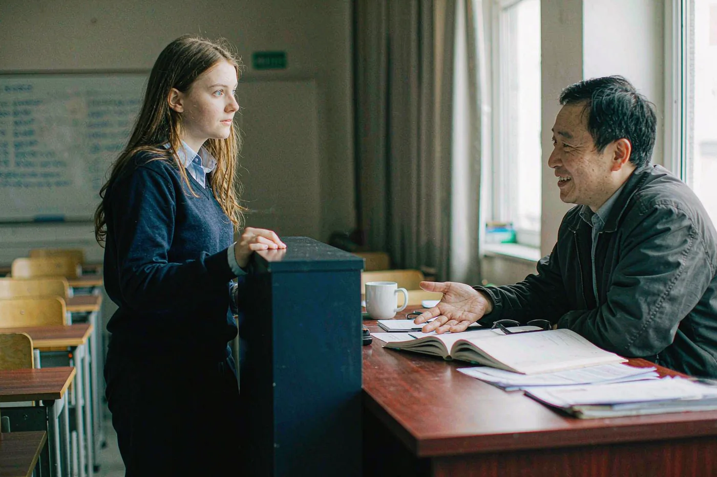 An international student asking a Chinese teacher a question after class