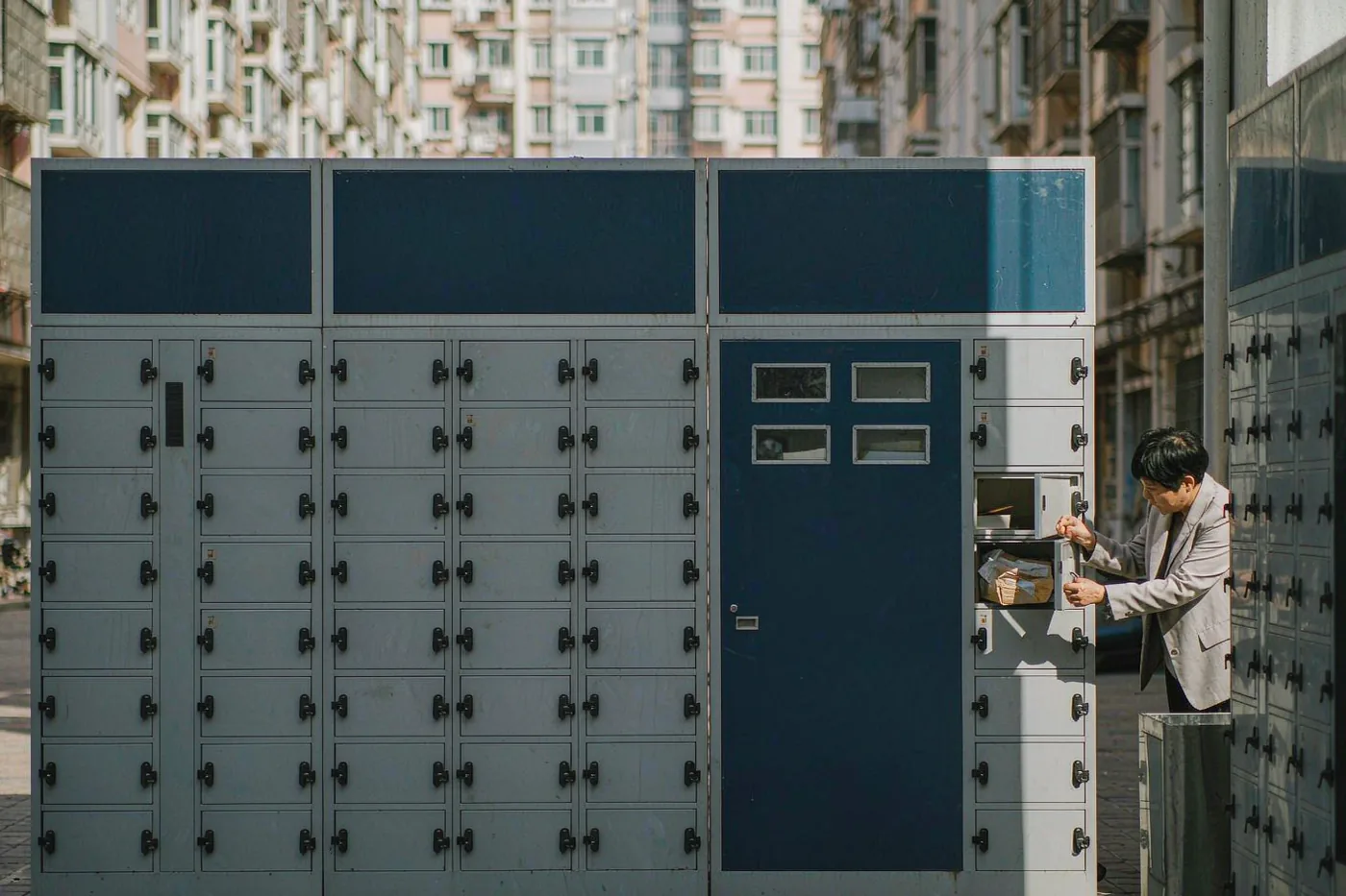 A resident collecting a parcel from smart lockers at a residential compound in China