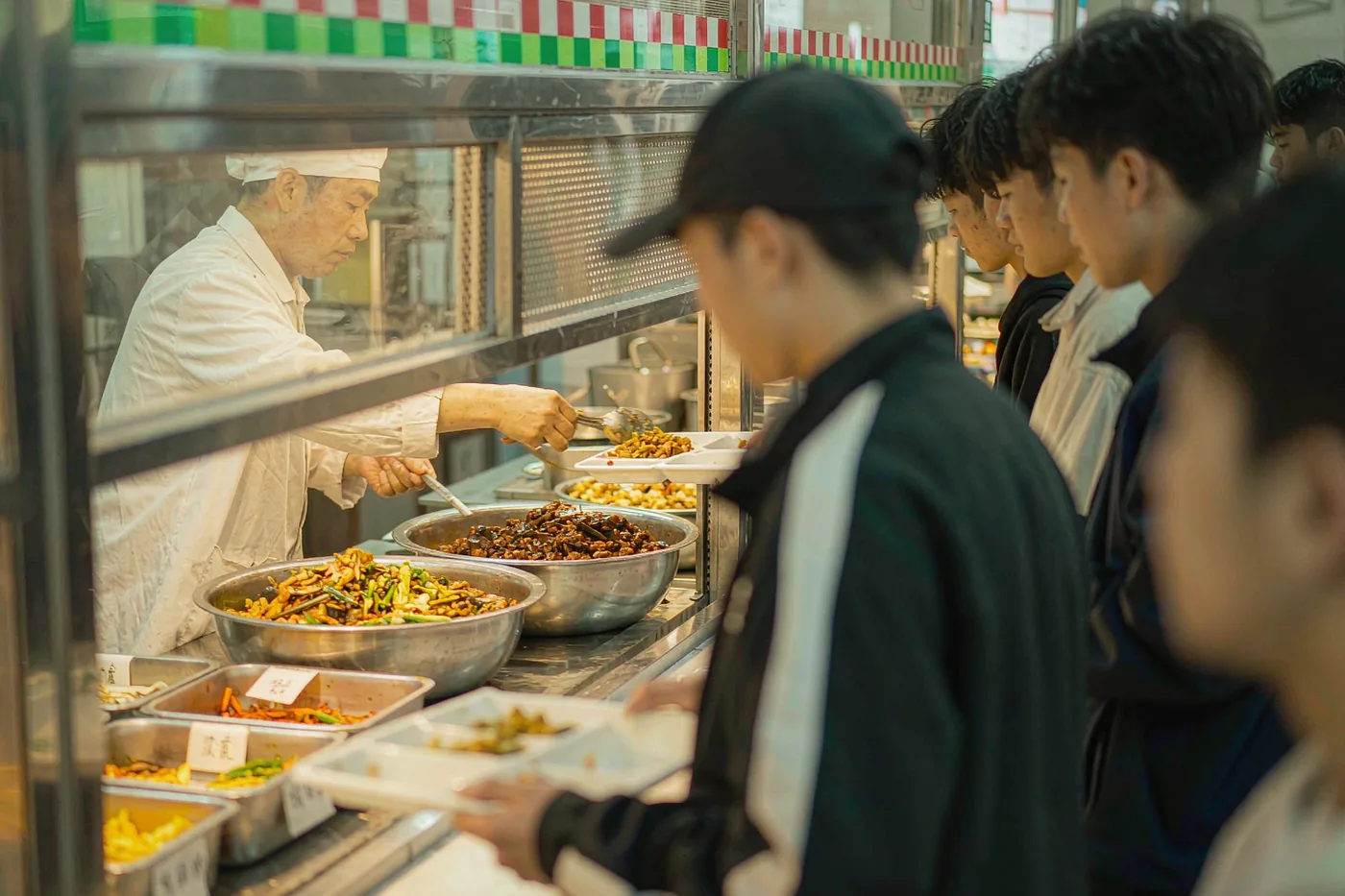 A serving counter with hot dishes at a Chinese university canteen