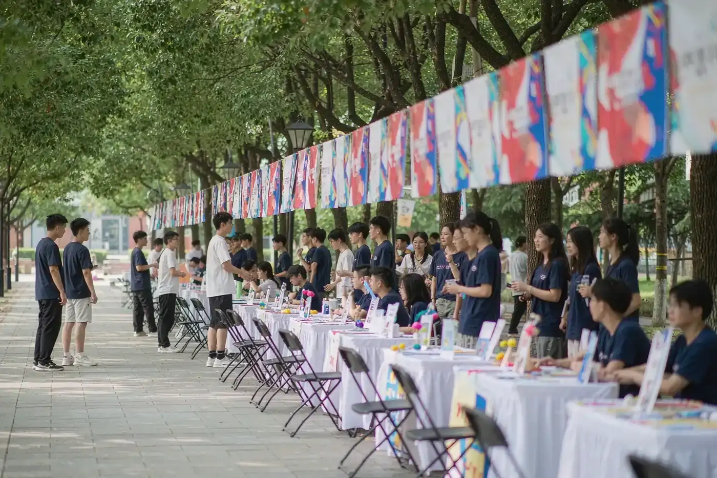 A university club fair with student stalls and banners on a Chinese campus