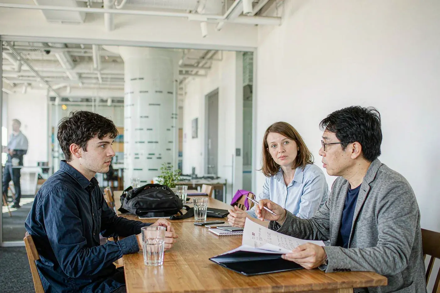 A candidate being interviewed by two Chinese interviewers in a meeting room